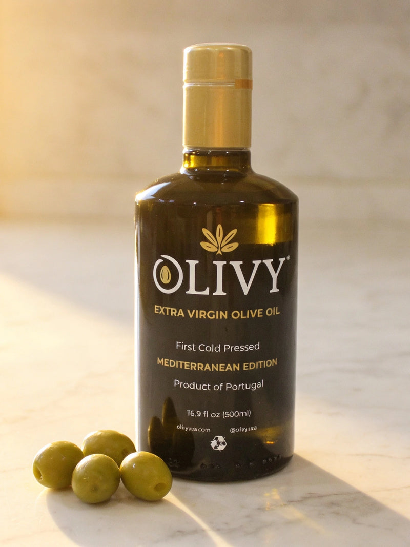 Bottle of Olivy Extra Virgin Olive Oil with olives on a marble surface