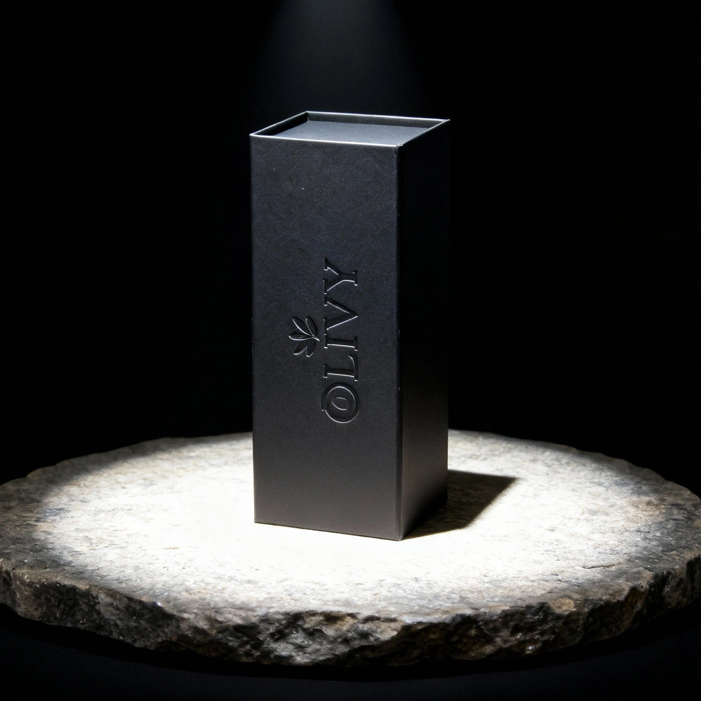Black rectangular box with 'OLIVY' branding on a stone platform against a black background