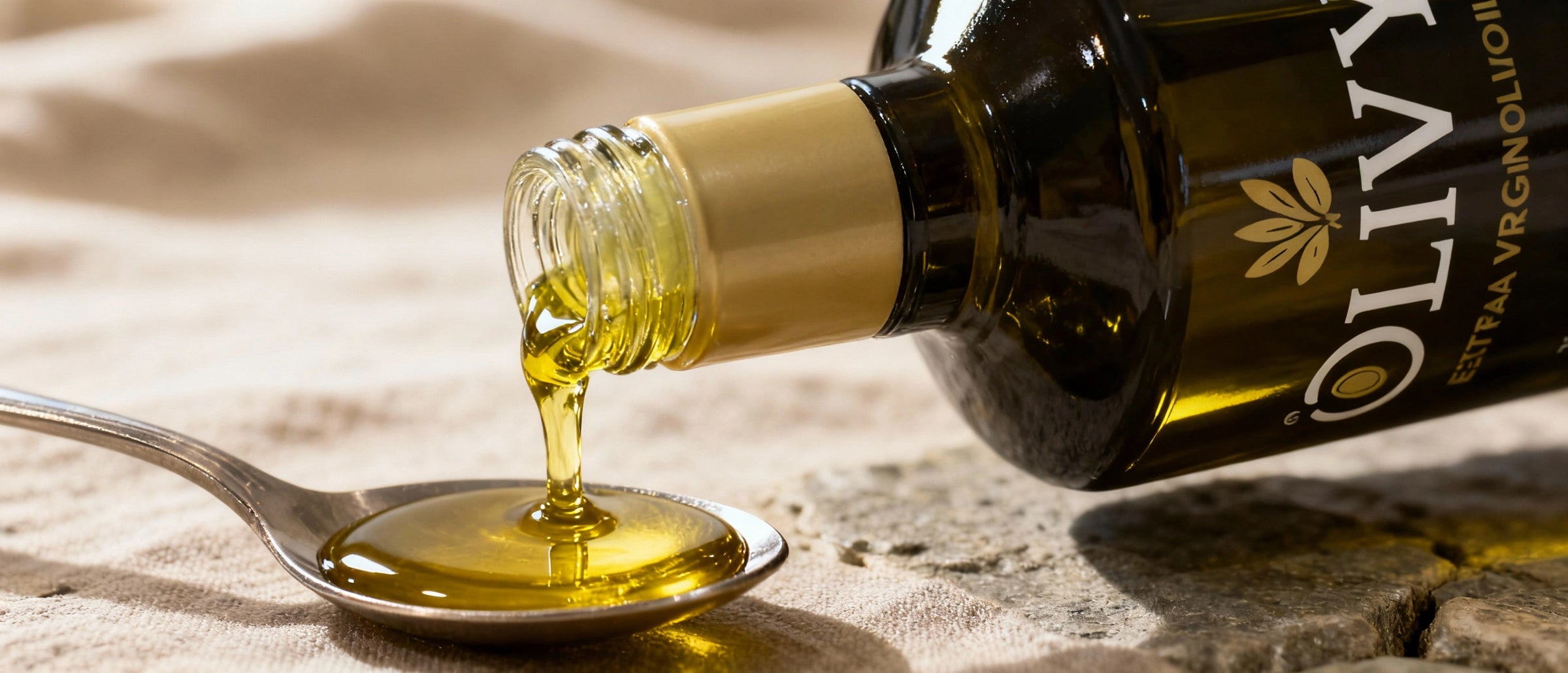 Olive oil being drizzled over a salad with cucumbers, tomatoes, and lettuce.