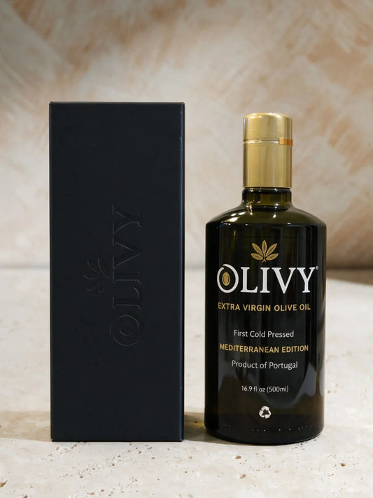 A bottle of OLIVY Extra Virgin Olive Oil next to its black packaging box, set against a neutral textured background.