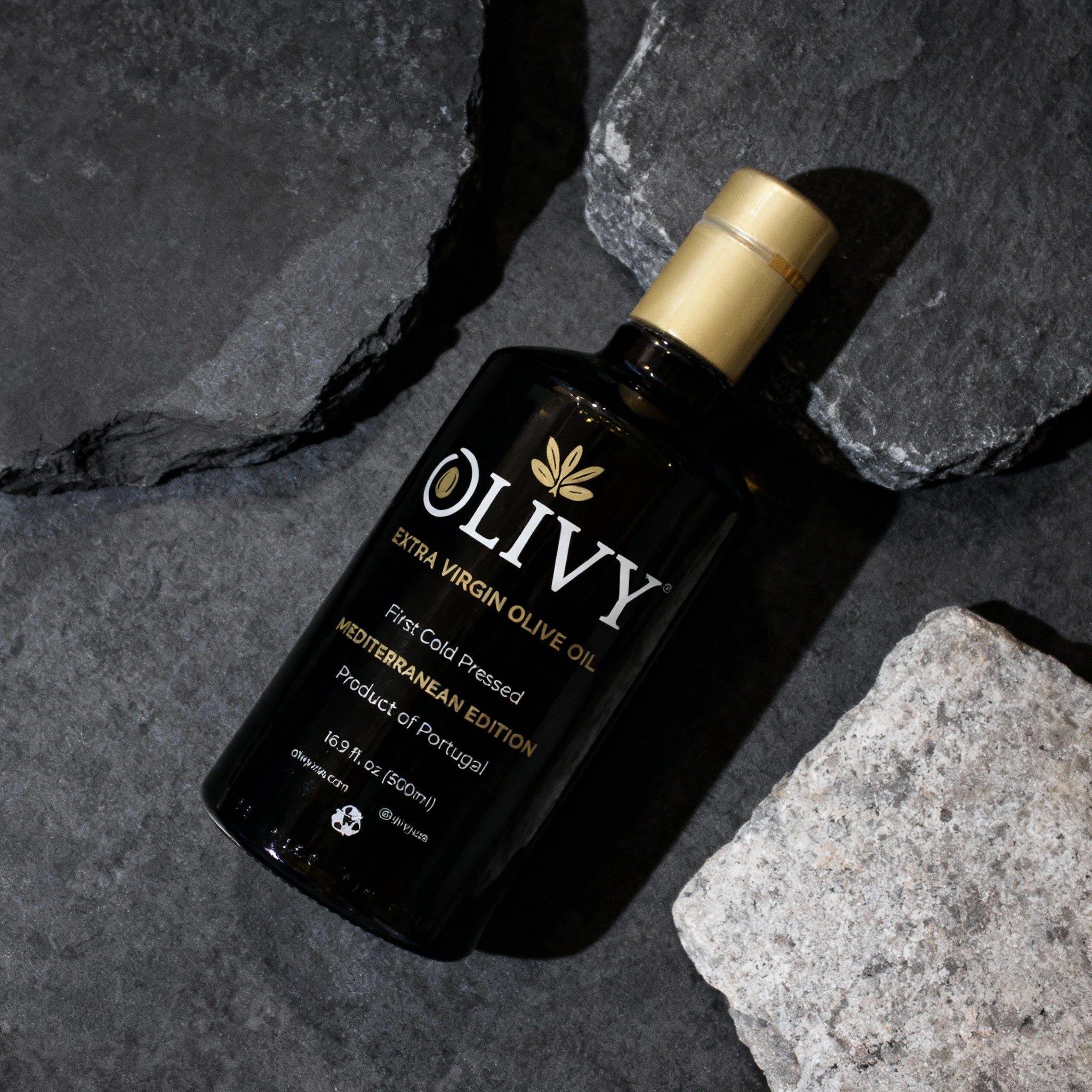 Bottle of OLIVY Extra Virgin Olive Oil on a dark stone surface